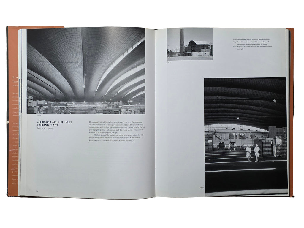 Open book showing black and white architectural photographs on a wooden surface