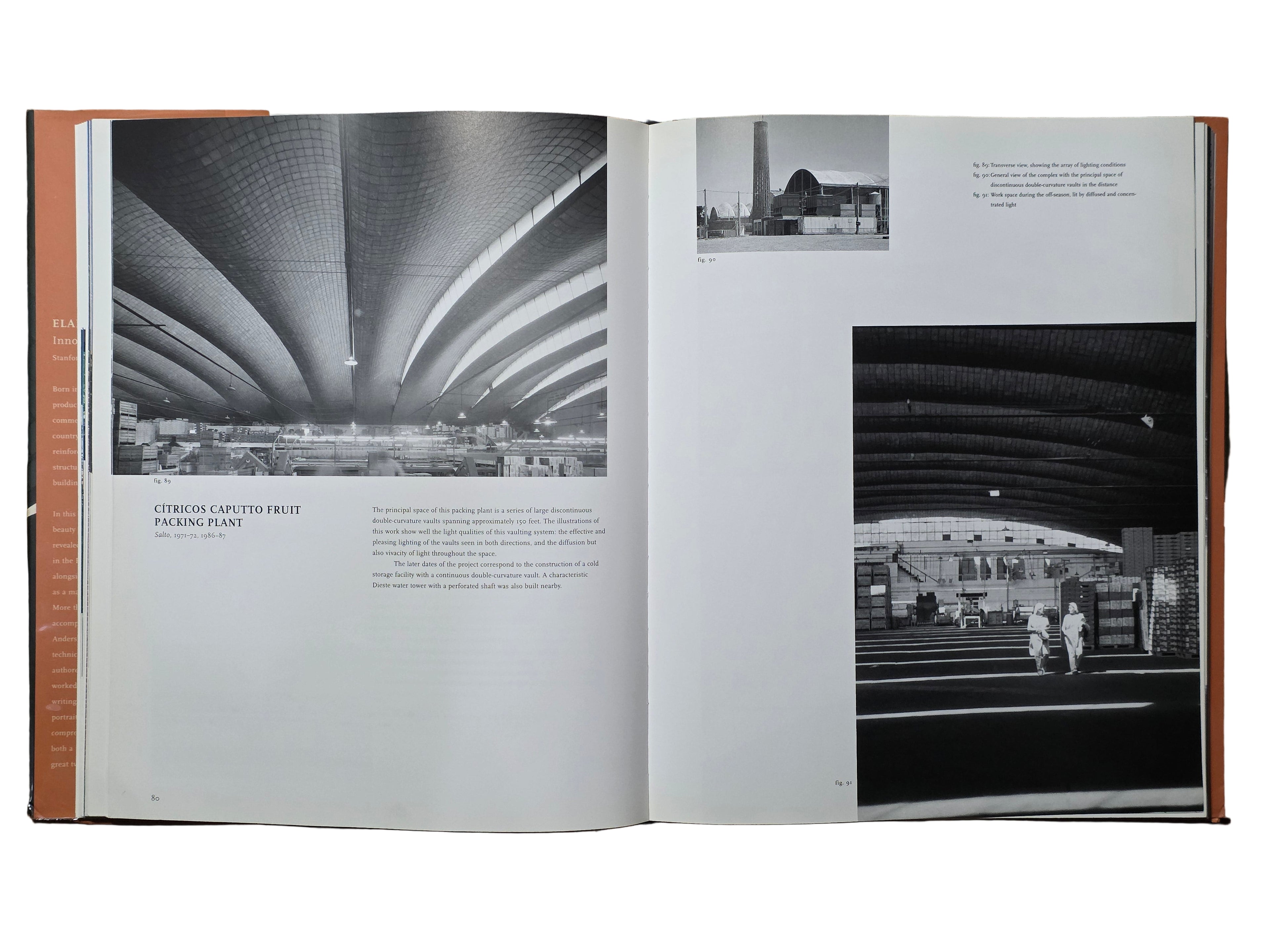 Open book showing black and white architectural photographs on a wooden surface