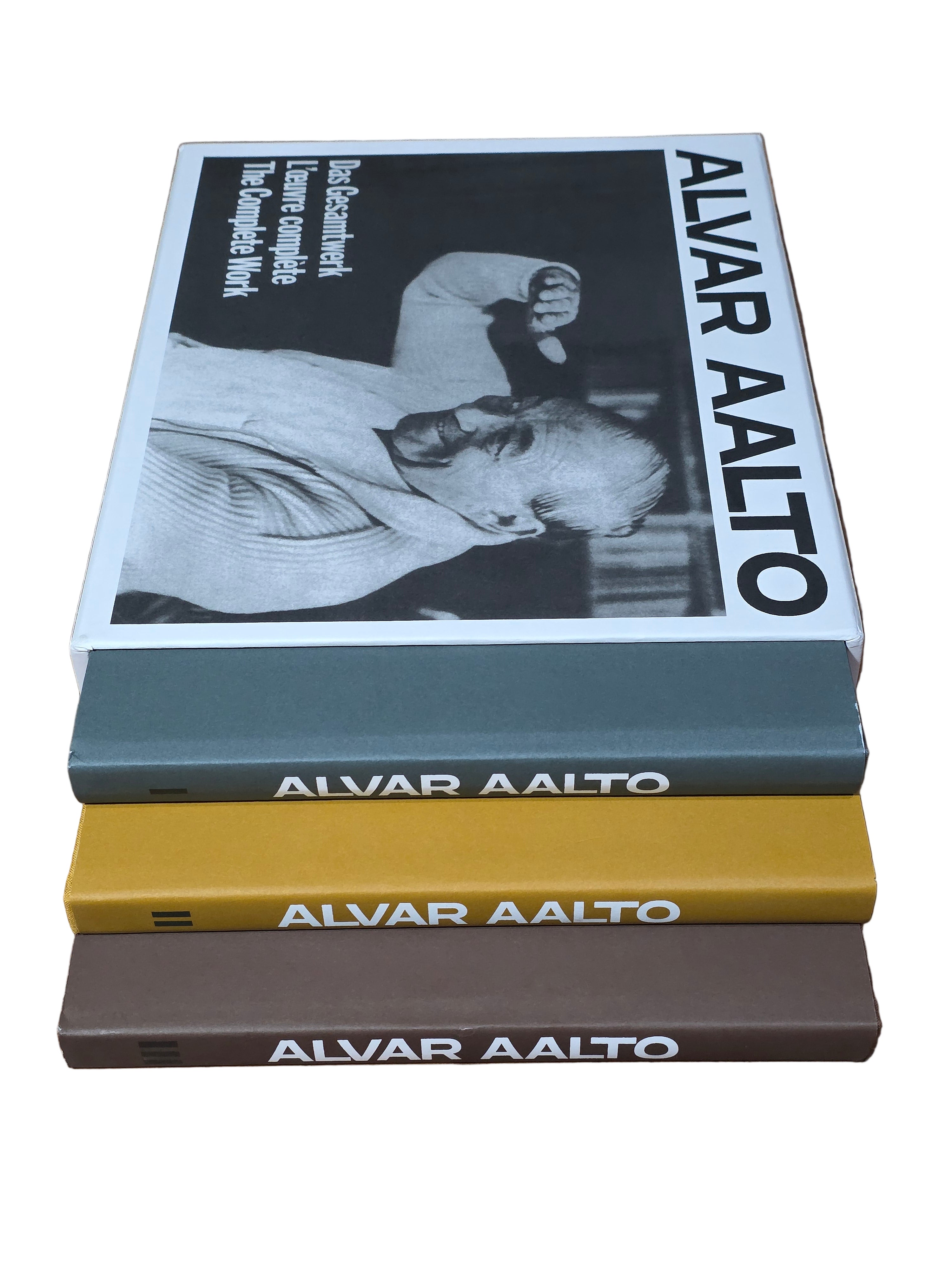 Three books titled 'Alvar Aalto' on a wooden surface